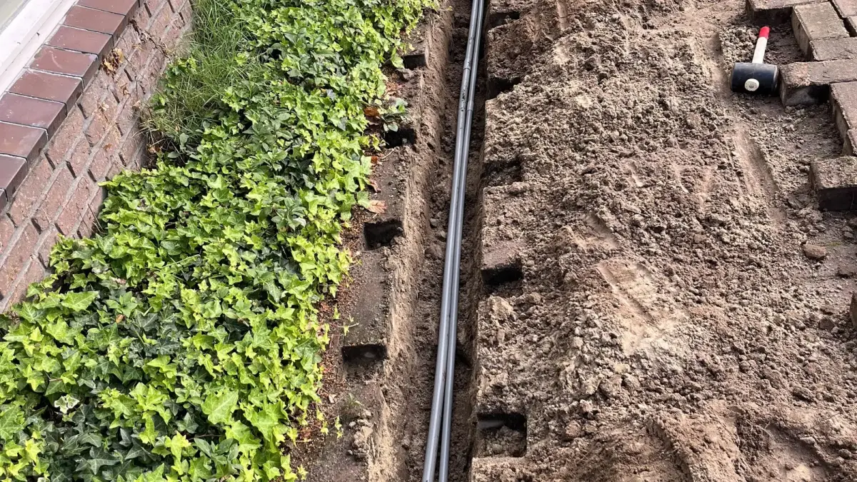 Sleuf in de tuin met de kabel naar de laadpaal