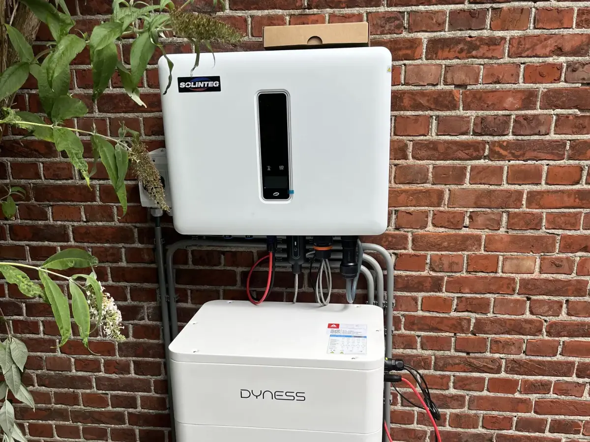 Thuisbatterij met omvormer aan een bakstenen muur